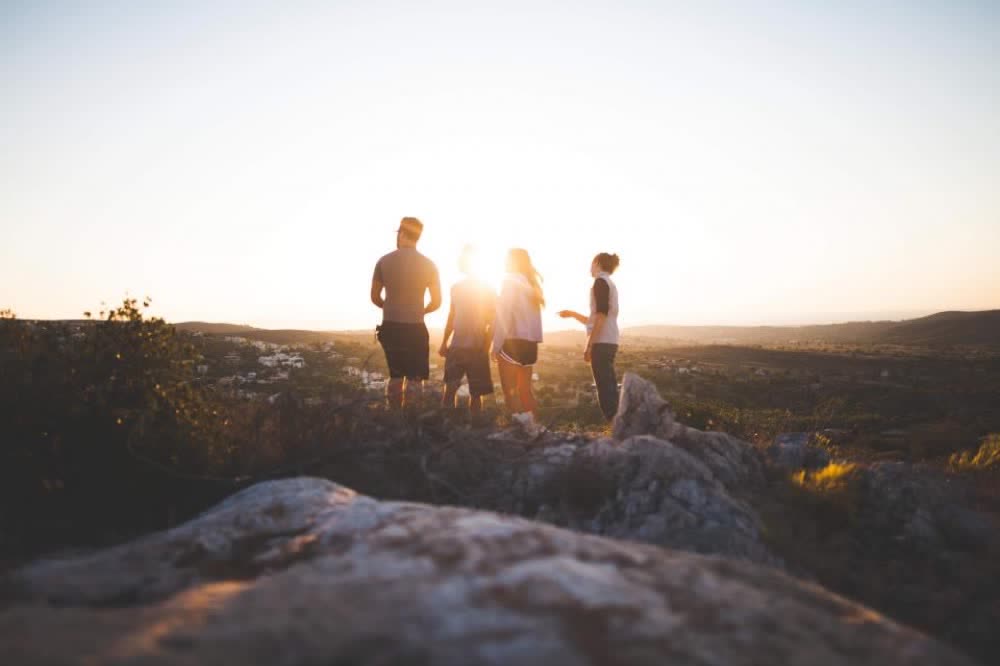Small group of walkers on a ridge at sunset